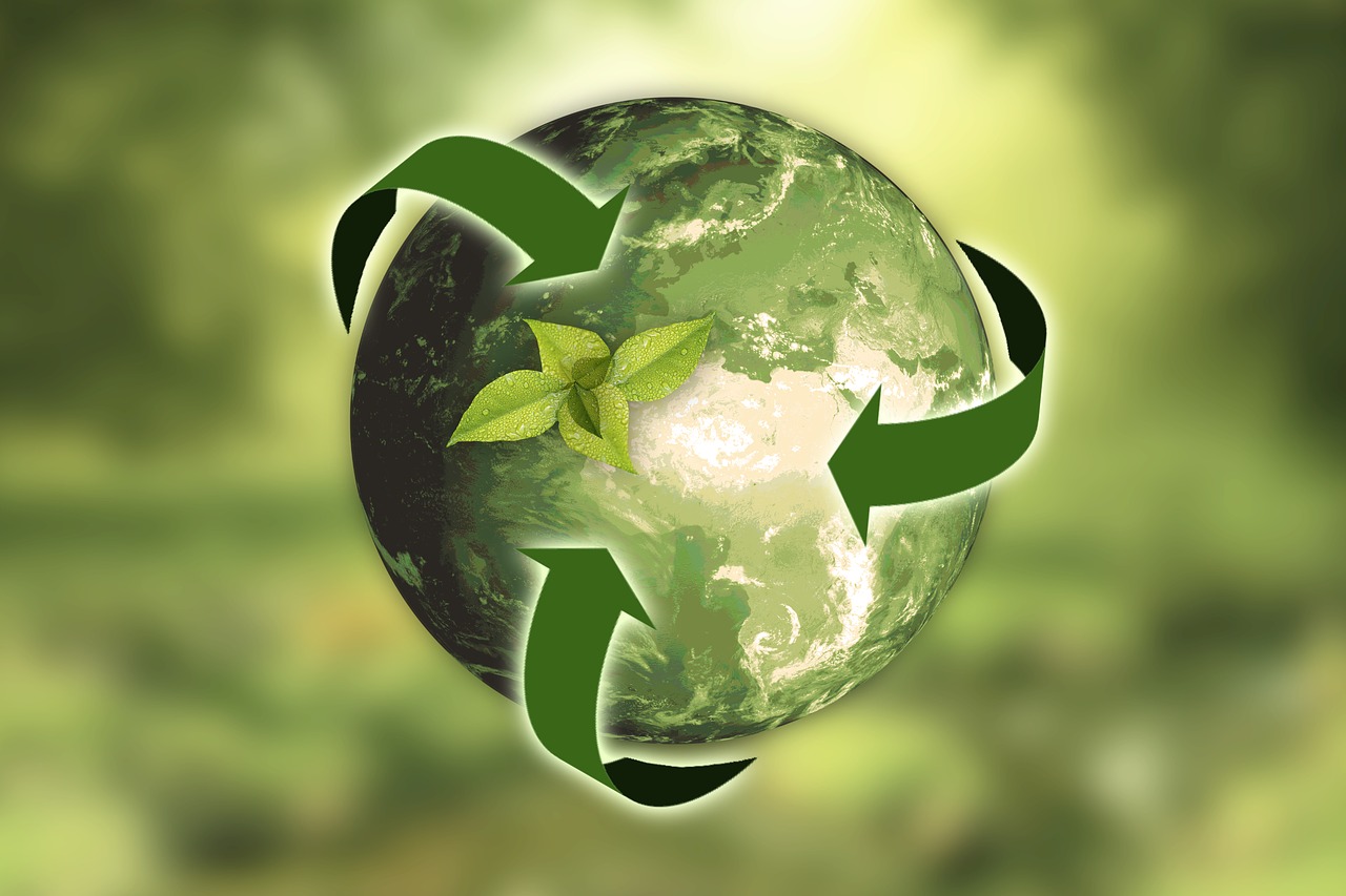 Grafika planety Ziemi z zielonymi strzałkami recyklingu wokół niej